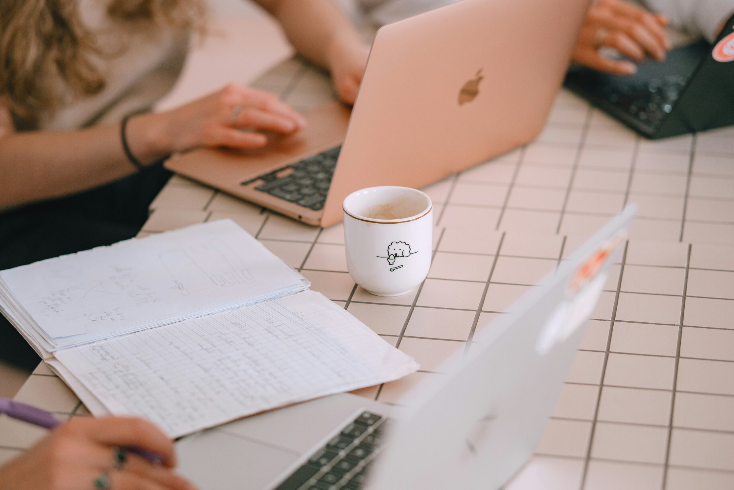 People working on laptops and notebooks to decide a digital marketing plan for small business owners.